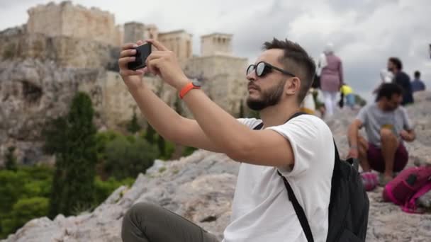 Mand blandt turister, der tager billeder med telefon af græsk Akropolis på Athens bakke – Stock-video