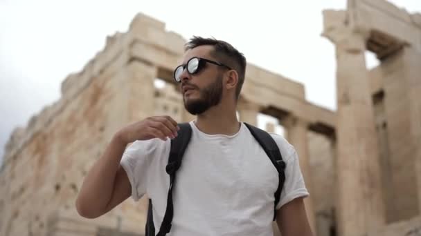 Toeristische mannen nemen een bril af om rond te kijken Acropolis ruïnes in Grieks Athene. — Stockvideo