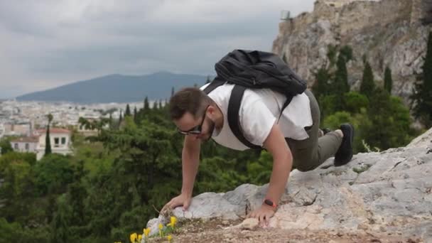 Tourist man fools around by smelling amazing flower during open air hiking trip. — Stock Video