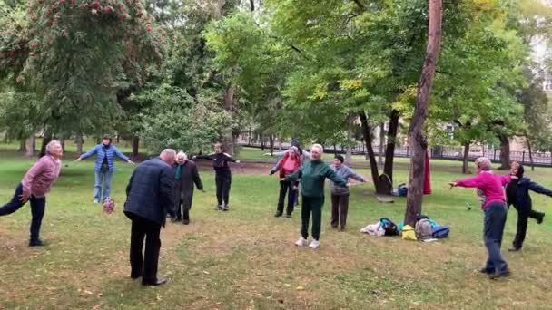 Ηλικιωμένη προπόνηση φυσικής κατάστασης των γυναικών με οδηγίες του ηλικιωμένου προπονητή στο πάρκο της πόλης. — Αρχείο Βίντεο
