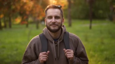 Kameraya bakan erkek turistin sakallı portresi. Sonbahar orman arka planı