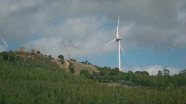 Elektrikli rüzgar türbini jeneratörü, yel değirmeni pervaneleri havada dönüyor. Yeşil enerji
