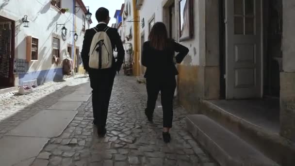 Familie, een paar studenten in pakken op toeristische wandeling. Middeleeuwse stadsarchitectuur. — Stockvideo