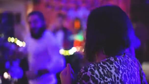Krásná brunetka dívka tanec s vousatým chlapem v blízkosti diskotéky DJ v nočním klubu party. — Stock video