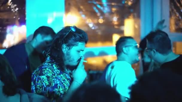 長い髪の髭の男踊りながら喫煙で夜のクラブパーティーレイヴイベント. — ストック動画