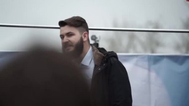 Mikrofonlu erkek spiker sahnede saldırganlığa hitap ediyor. İsyan eylemcisi sahnede..