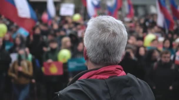 マイク付きの抗議スピーカーは、ロシアの旗で群衆を結集するスピーチを与えます — ストック動画