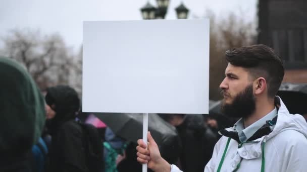 Uomo durante la pioggia con pannello poster pubblicitario mockup vuoto per logo pubblicitario. — Video Stock