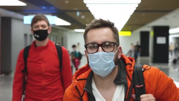 Hombre en máscara facial y gafas saliendo del aeropuerto o abordando avión en pandemias. — Vídeos de Stock