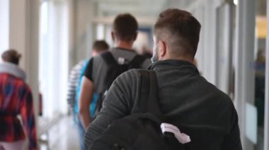 Yüz maskeli ve gözlüklü bir erkek havaalanından ayrılıyor ya da salgın hastalıklar içinde uçağa biniyor..