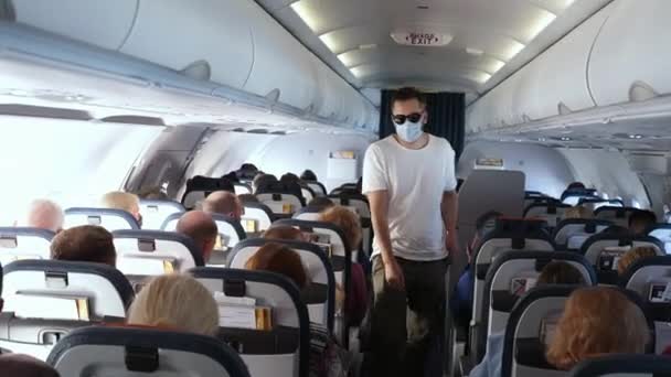 Man reiziger loopt voorbij zittende passagiers om plaats te nemen, vliegtuig instappen. — Stockvideo
