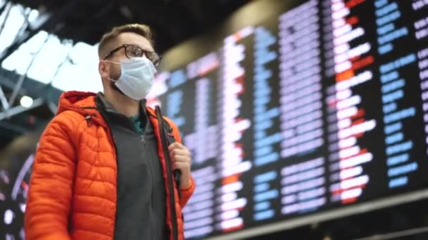 コロナウイルスの観光便の制限。男はコロナウイルスフェイスマスクで旅. — ストック動画