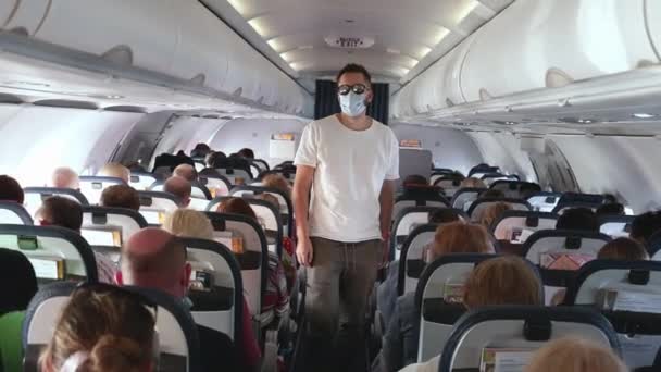 Manlig passagerare går förbi sittande människor att ta hans plats, ombordstigning på flygplan. — Stockvideo