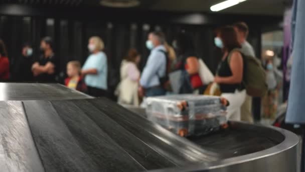 Turistas e viajantes esperam pela chegada de malas despachadas, malas no terminal. — Vídeo de Stock