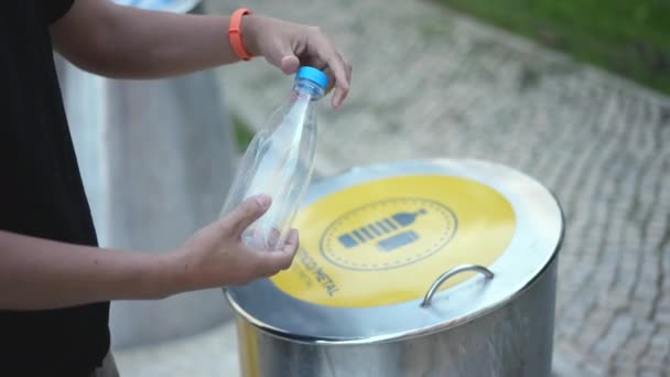 Guy jette la bouteille dans la poubelle pour les déchets plastiques et métalliques. Recyclage séparé. — Video