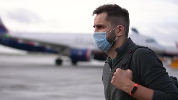 Passenger guy in mask walking towards plane to enter. Airplane flight boarding — Stock Video