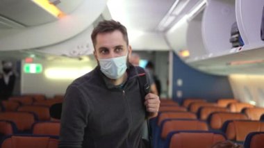 Çantaları yükleyen yolcular, bavullar raflarda. Uçağa biniş.