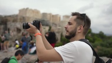 Kameralı adam Atina 'nın ünlü simgesi Akropolis tapınağının fotoğraflarını çekiyor.