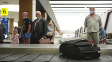 Yolcular kontrol edilen bagajlarını taşıyan atlı karınca kemerlerini taşıyorlar.