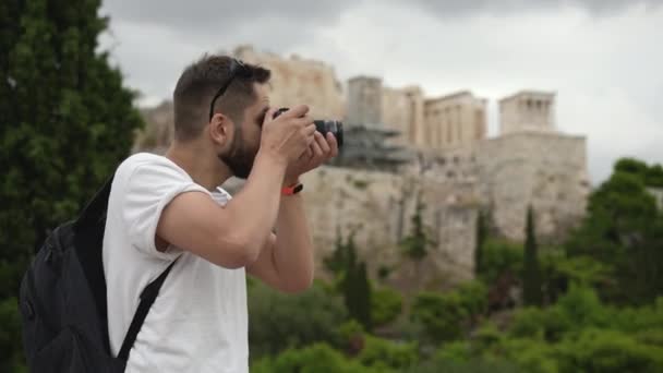 Homme photographe en voyage à Athènes prend des photos de l'ancienne colline de l'Acropole. — Video