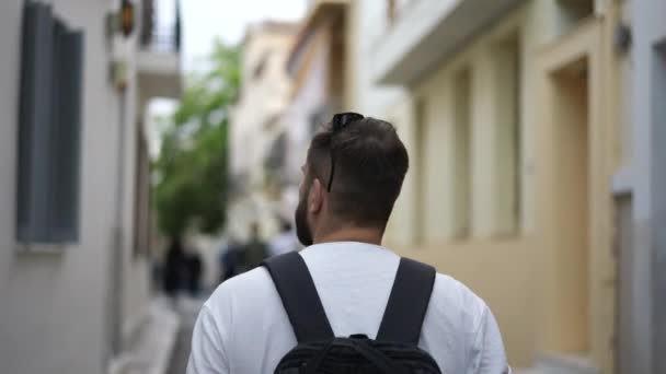 Toeristische wandelingen op straten van de Europese Griekse stad en neemt foto 's van oude huizen — Stockvideo