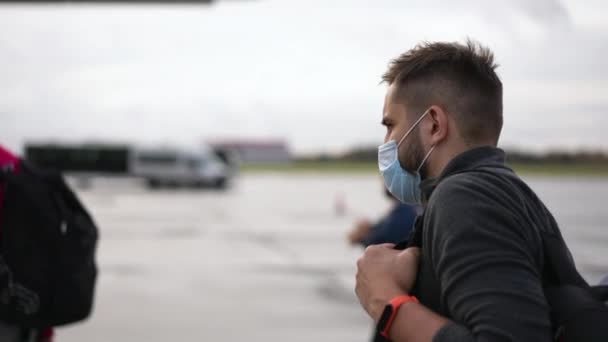 Cestující muži v maskáčích nastupují do letadla. Pěšky mimo letištní terminál. — Stock video