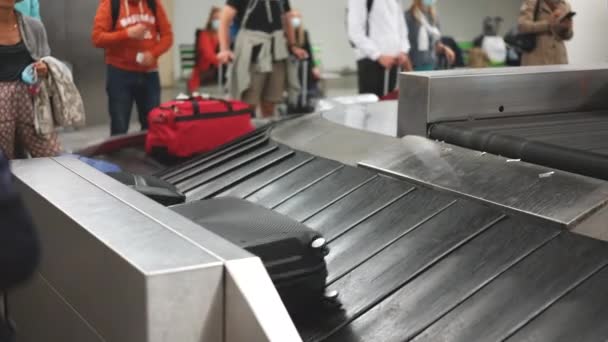 Personas que esperan la llegada de su equipaje al vestíbulo del aeropuerto antes del vuelo. — Vídeos de Stock