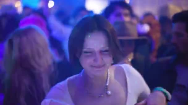 Hezká brunetka bílá Kavkazská dívka tančí mezi davem klubů lidí. — Stock video