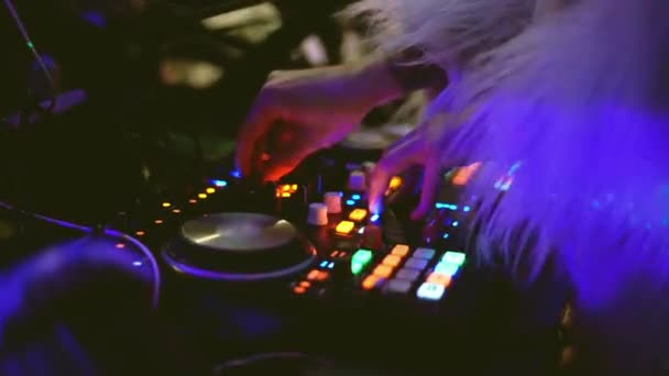 Night club dj in fur coat at evening party at remote panel, controlling console. — Stock Video