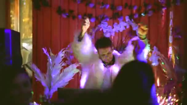 Fiesta nocturna. Discoteca DJ chico actuando para multitud de personas bailando. — Vídeos de Stock