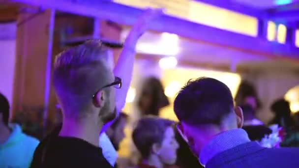 Случайные хипстеры танцуют на вечеринке в клубе по выходным, отвлекаются на смартфон. — стоковое видео