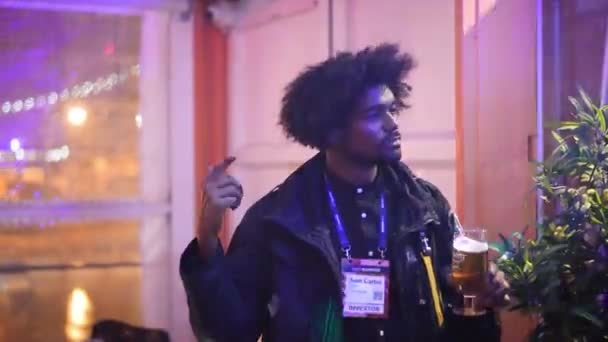 Boldog afro-amerikai férfi sörtánccal az éjszakai klubban. Este hűvös.. — Stock videók