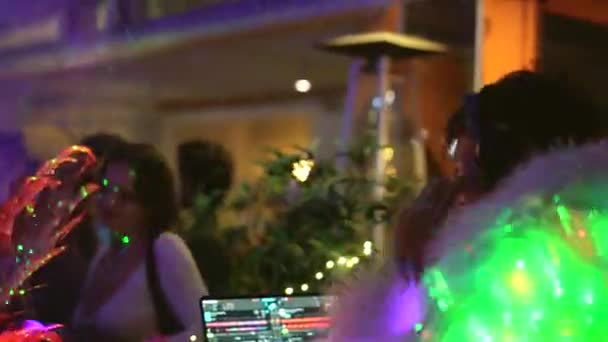 Impressionnant DJ dans les écouteurs et manteau en fourrure blanche avec lumières led à la soirée de boîte de nuit. — Video