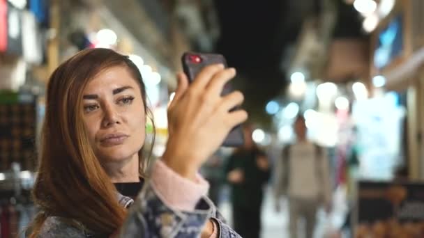 Härlig dam ta selfie på kvällen gata i europeisk stad i sen skymning tid. — Stockvideo