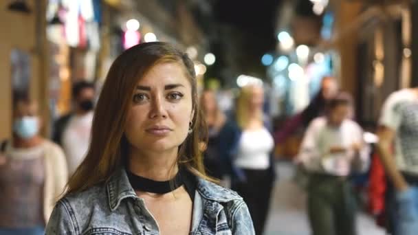 Femme regarde la caméra, sourit et pose pour le portrait du visage sur la rue du soir. — Video