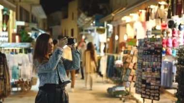 Kadın turist fotoğrafçı Atina sokaklarında kamerayla fotoğraf çekiyor.