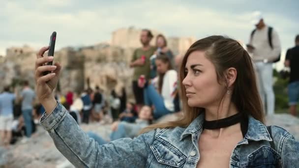 Kadın, Atina tepesindeki kalabalığın arasında Yunan Akropolünün telefonuyla fotoğraf çekiyor. — Stok video