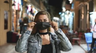 Coronavirus maskesi takarken kameraya bakan trend bir kadının portresi.