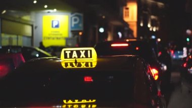 Taksi şoförü yolcuları, müşterileri bekliyor. Şehir caddesinde geç saatlerde taksi servisi.