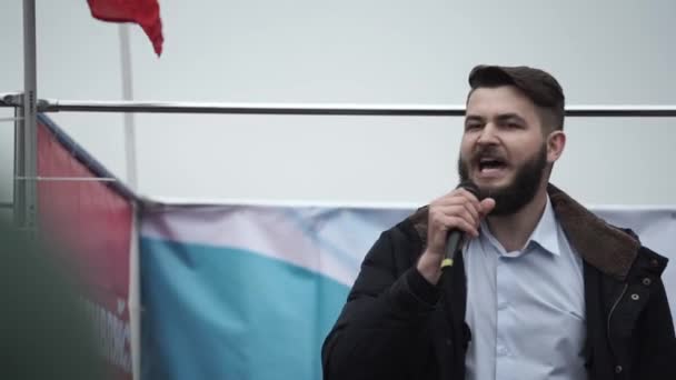 Mikrofonlu erkek spiker sahnede saldırganlığa hitap ediyor. İsyan eylemcisi sahnede.. — Stok video