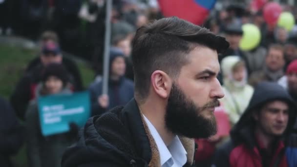 Portrait of bearded male protester on crowded city street during political rally — Stock Video