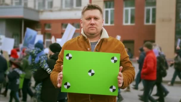 拿着绿色屏幕横幅看着相机的积极分子的人脸肖像。抗议广告 — 图库视频影像