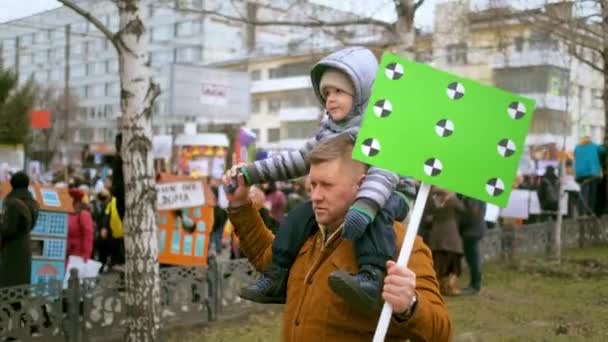 Politieke rally voor bouwfraude. Papa met modelbord, zoon op de schouders.. — Stockvideo