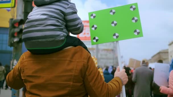 Familia de padre e hijo en mitin con espacio en blanco cromakey bandera maqueta. — Vídeos de Stock