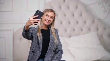 Çekici kız yatak odasında sosyal medyası için fotoğraf ya da video çekiyor..