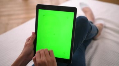 Kadın dokunur, siler ve yeşil ekranları yakınlaştırır. Tablet choma anahtarı ve maket.