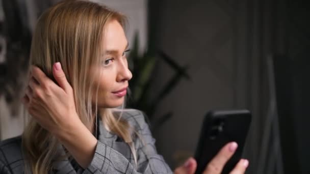 Mulher bonito tira foto, filmes de vídeo de si mesma em seu apartamento durante a noite. — Vídeo de Stock