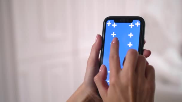 Vrouw dia 's, scrollen op en neer blauw chroma toetsenbord scherm in smartphone app. — Stockvideo