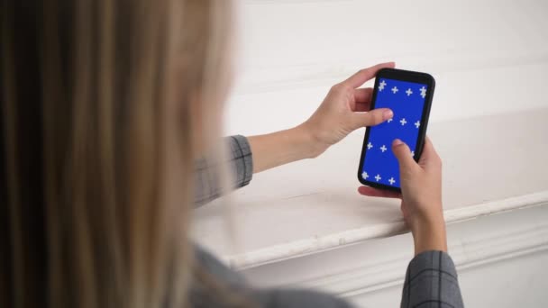 Female person zooms in and out blue chromakey screen with fingers on surface. — Stock Video