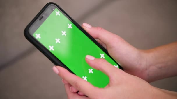 Gros plan des doigts féminins glisser vers la gauche et vers la droite sur l'application de l'écran vert — Video